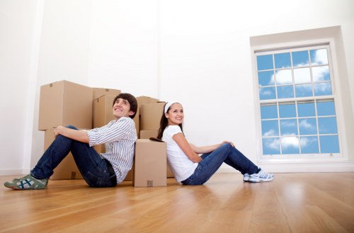 Professional movers carrying items down stairs in a Haringey flat block