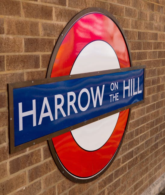 A close-up view of a round London Underground station sign mounted on a brick wall, displaying the station name 'Harrow on the Hill' in white uppercase letters on a blue rectangular background. The sign features the characteristic red circle with a white center and a blue bar across the middle. The brick wall behind the sign is reddish-brown with visible mortar joints, indicating an indoor or station environment. The signage may be relevant to home relocation or local moving services offered by Man and Van Haringey, as part of their house removal and furniture transport operations.